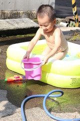ビニールプールで遊ぶ日本の男の子（3歳児）