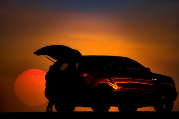 Fototapeta na wymiar Silhouette of a car behind the big sun setting at Lam Pao Dam, Kalasin Province, Thailand