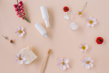 Obraz na płótnie Canvas Flat lay of beauty product mock ups, organic soap, flower buds on beige background. Skin care and body care concept. Copy space.