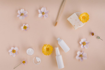 Skin care and body care products mock up, flowers on beige background.