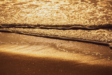 Closeup golden sea wave in sunrise or sunset, Nature background
