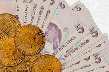 5 Turkish lira bills and golden bitcoins. Cryptocurrency investment concept. Crypto mining or...