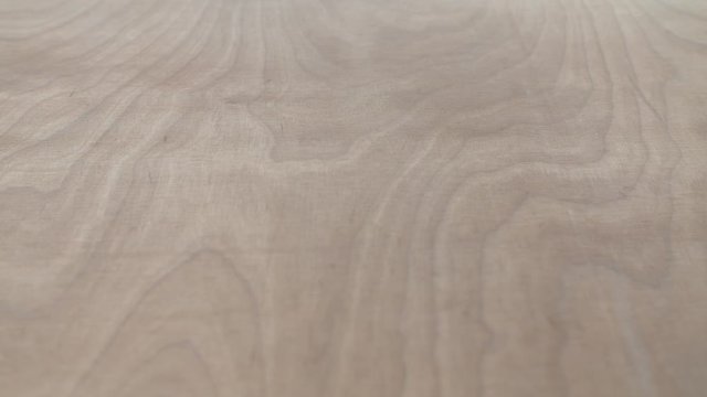 Background, texture - surface of plywood. Close up shot, camera slowly moving along the table on slider.