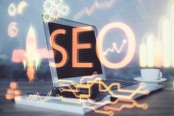 Multi exposure of table with computer and seo drawing hologram. Search optimization concept.