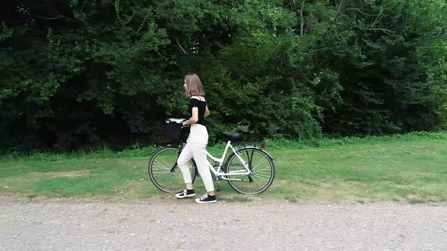 Jeune fille qui pousse son v&eacute;lo 