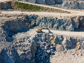 Crushed stone quarry outside. A digger working at a quarry plant. Gravel mining for use in the construction industry