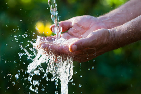 Muslim man washes his hands before prayer ritual cleansing.