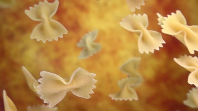  Dry pasta Farfalle is falling diagonally and rotting on a yellow ochre background in slow motion