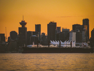 Beautiful Vancouver skyline shot seen from north at sunset with yellow colors.