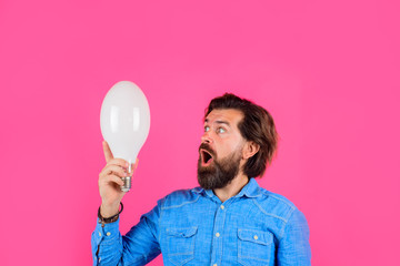 Good idea. Birth of ideas. Surprised man with lamp. Idea. Lightbulb in hand. Bearded man holds light bulb. Energy and electricity. Surprised man with light bulb.