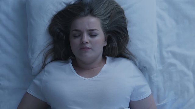 Annoyed obese lady sleepless at night, uncomfortable bed irregular sleep routine