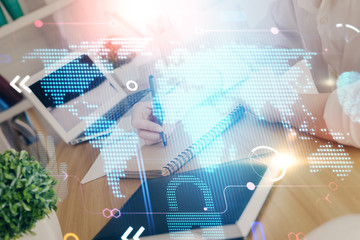 Double exposure of hands making notes with world map hologram and data theme icons. Concept of international network data.