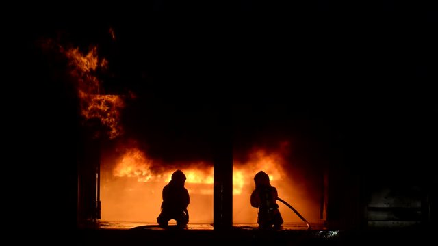 Firefighters spraying water to put out a brutal fire inside the building.