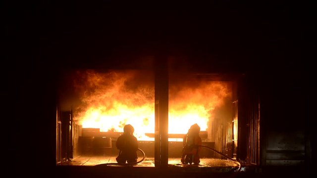 Firefighters spraying water to put out a brutal fire inside the building.