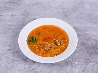 Soup kharcho with meat on a gray background