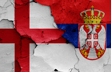 flags of England and Serbia painted on cracked wall