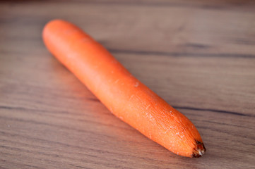 Fresh ripe carrot on wooden background