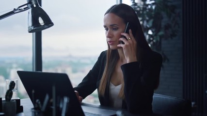 Businesswoman answering on phone call at office. Lady talking on smartphone