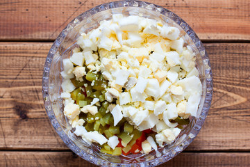 Step-by-step preparation of Olivier salad with beef, step 3 - adding chopped boiled eggs, top view, selective focus