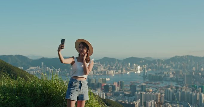 Woman use of mobile phone and take selfie on mountain