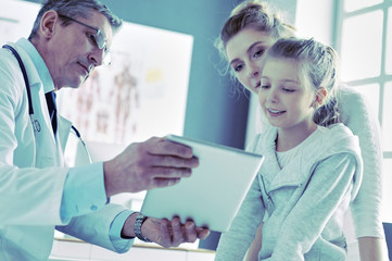 Fototapeta premium Little girl with her mother at a doctor on consultation