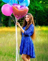 Girl hand holding colorful balloons made with retro vintage filter effect, happy birthday summer concept and wedding honeymoon party
