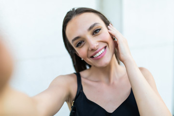 Fototapeta premium Young and beautiful. Pretty girl making selfie while having a walk around the city