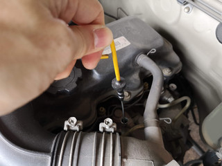 The engine oil level dipstick is pulled.