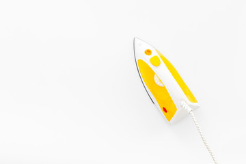 Yellow iron on ironing board. Top view, copy space