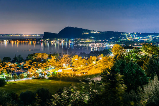Night time in Manerba del Garda with the silhouettes of the mountains in the background on Lake Garda, Italy