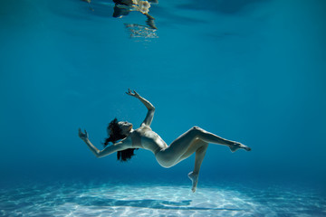 A woman with nice body dancing under water.Underwater photo