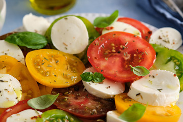 Caprese salad with mozzarella, colored tomatoes and fresh basil.