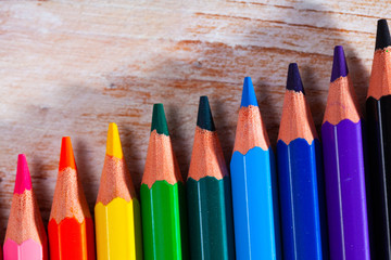Variety of colorful pencils lying on wooden table. Creativity concept..