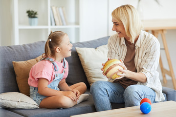 Happy mother showing the model of the planets to her daughter with down syndrome and they laughing...