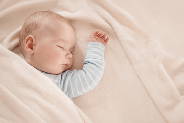 Baby sleeping covered with soft white blanket