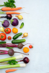 Vertical layout of fresh seasonal vegetables on a light background. Side space for text.