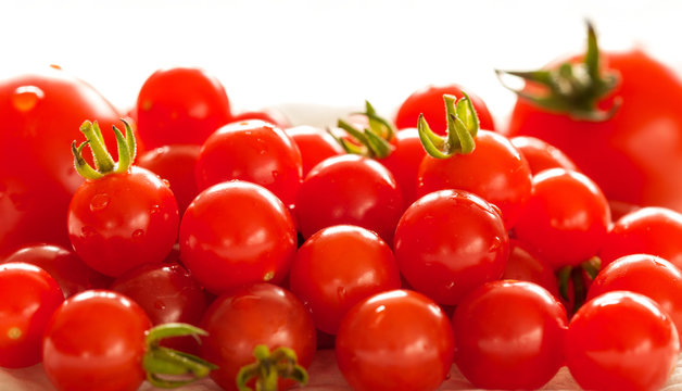 Freshly natural red tomatoes background. natural raw fruits close up. Healthy eating and nutrition. Fresh ripe tomato Solanum pimpinellifolium (Synonym Lycopersicon pimpinellifolium)