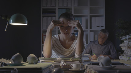 Sad office worker working at night in the office