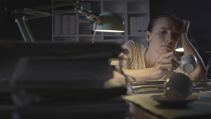 Frustrated woman working in the office at night