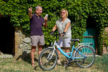 senior couple looking for direction in bike trip in countryside outdoor location - Concept of active elderly and interaction with new technologies