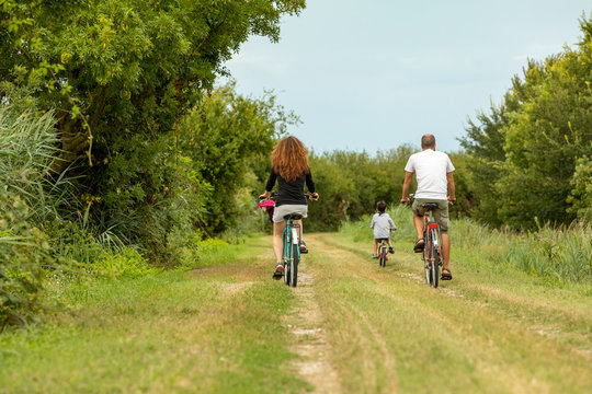Young family on a country bike ride in the beach village of Caorle in the Provice of Veneto in Italy.