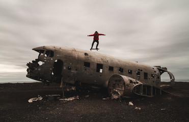 Skater jumping on a plane - Man on top of Solheimasandur Plane Wreck in Iceland