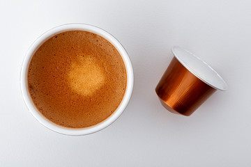 Tasse de café espresso vue du dessus et sa capsule vue de dessus