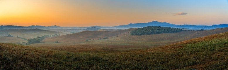 Obraz premium Beautiful sunrise over the Tuscany hills and fields. Travel destination Tuscany