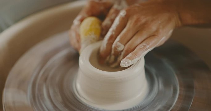 Young woman making pottery in the studio, handmade ceramics, close up detail of hands and clay