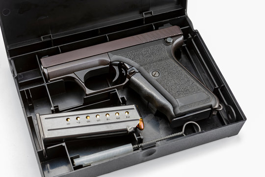 Automatic gun and bullets in a plastic hard case on white background