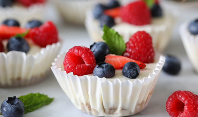 Mini cheesecake with blueberry and raspberry topping, sweet summer treat. Close up