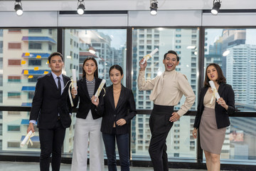 Obraz premium Business office workers celebrate a great acheivement together after major effort. Award of great success by working together in a business office. Moment of appreciation with team sprite