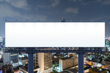 Blank white road billboard with Bangkok cityscape background at night time. Street advertising poster, mock up, 3D rendering. Front view. The concept of marketing communication to promote idea. © VideoFlow