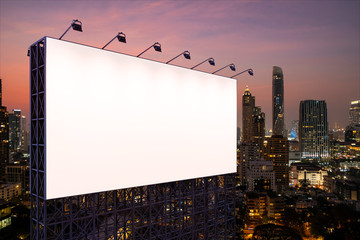 Blank white road billboard with Bangkok cityscape background at night time. Street advertising poster, mock up, 3D rendering. Side view. The concept of marketing communication to sell idea.